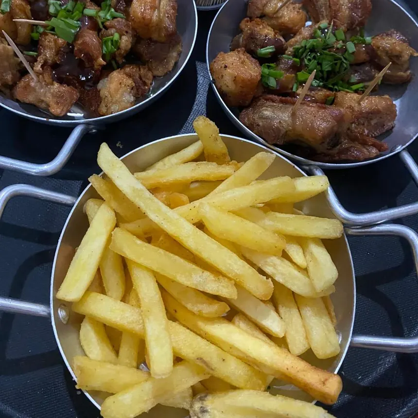 Torresmo e batata frita servidos em panelinhas