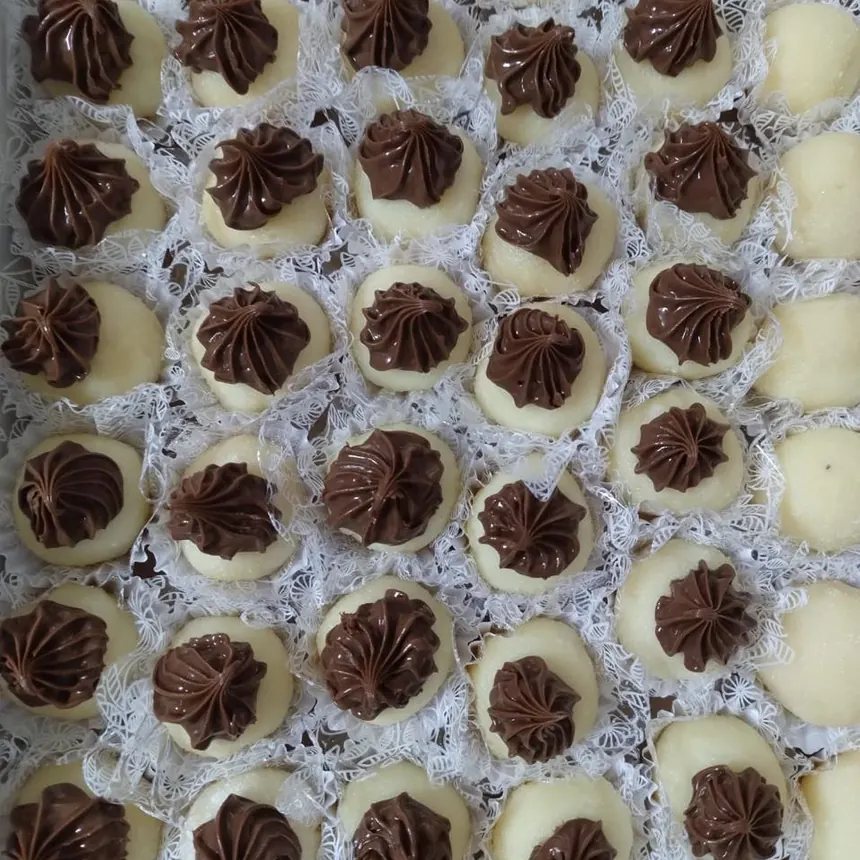 Docinhos brancos com bico de chocolate em forminhas