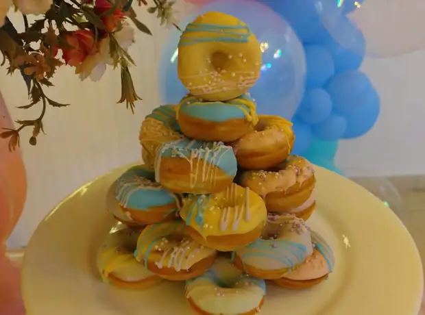 Torre de donuts com arco de balões rosa e azul