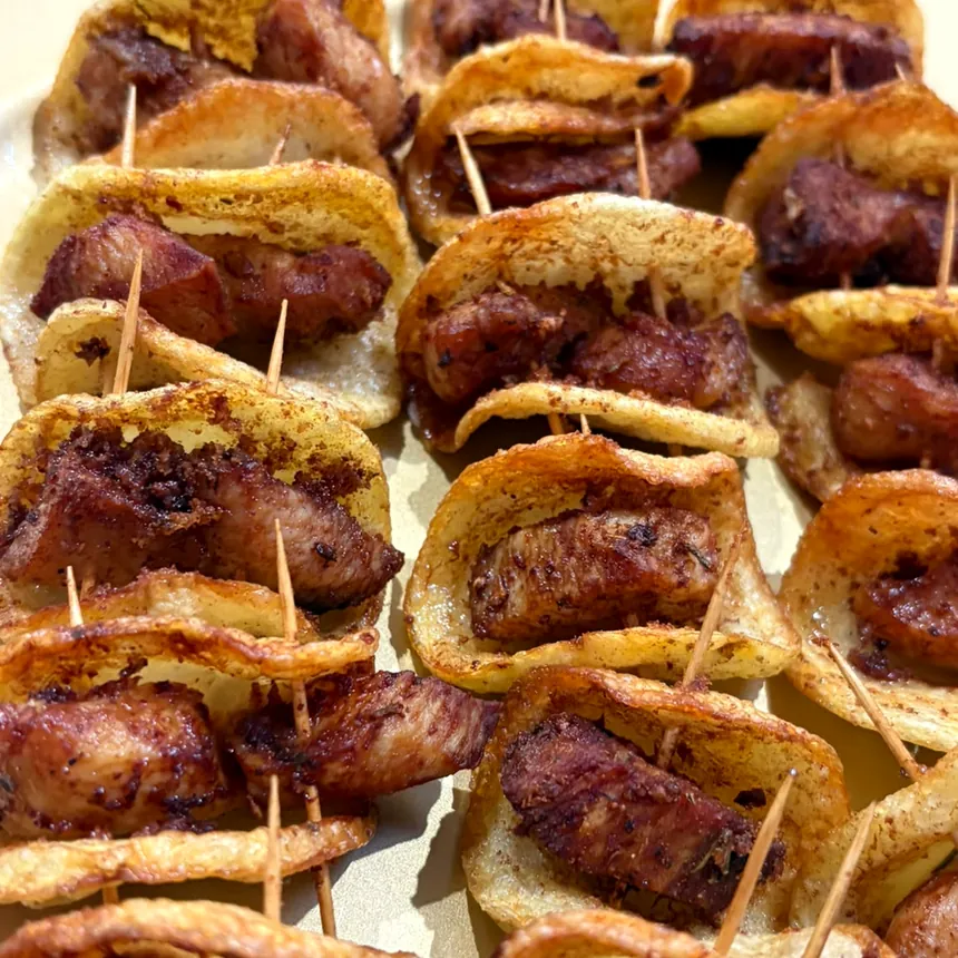 Canapés de chips de batata com cubos de linguiça em espetinhos individuais