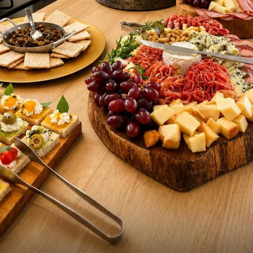 Tábua de madeira com queijos, uvas, embutidos e antepastos